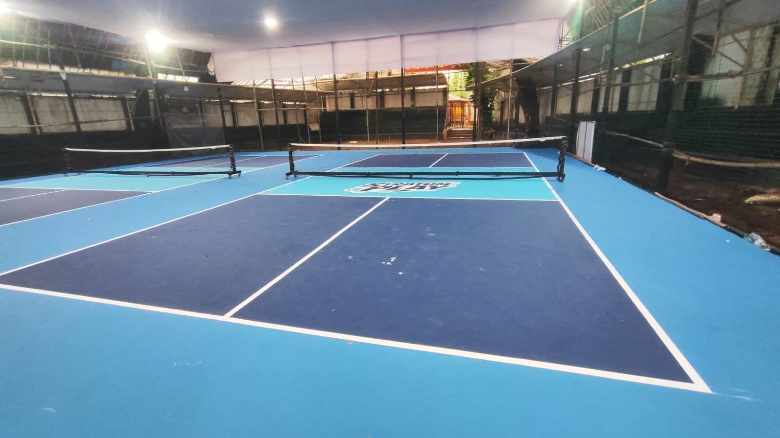 The floodlit pickleball courts at Stratum Play, Malad West: two nets set up under cover, ready for play